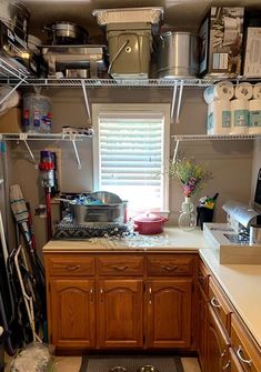 a kitchen with lots of clutter on the shelves