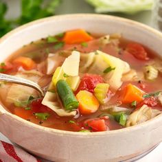 a bowl of vegetable soup with a spoon in it