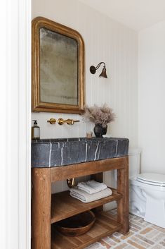 a bathroom with a sink, toilet and mirror