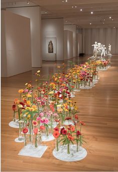 a bunch of vases with flowers in them on the floor next to each other