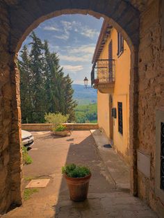 an arch leading to a building with a view of the mountains in the back ground