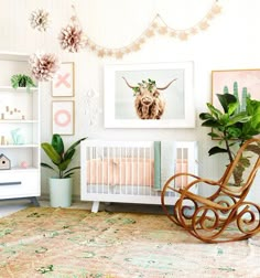 a baby's room with a rocking chair and pictures on the wall