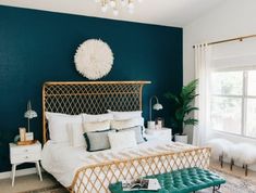 a bedroom with blue walls and white bedding in the center, along with a green rug on the floor