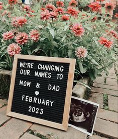 a sign that says we're changing our names to mom and dad in front of some flowers