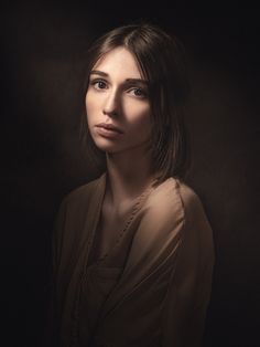 a woman is posing for a portrait in the dark