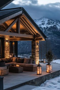 an outdoor living area with candles lit up in front of a mountain view at night