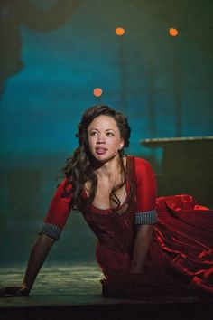 a woman in a red dress sitting on the ground