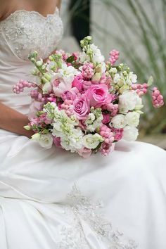 a bridal holding a bouquet of pink and white flowers