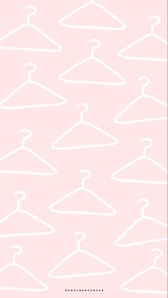 a pink background with white clothes hangers