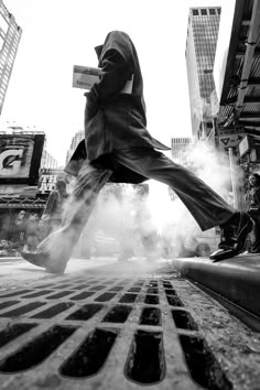 a man in a suit is walking down the street with his foot on a grate