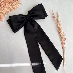 Black shiny satin hair bow with long tails for women.  Our products are handmade with love and care using high quality fabric in our studio in England.  📏The bow measures  24 cm in width 9.50 cm in height  Tail is  36 cm long (measured to the longest point) 📍Attachment:  📍Barrette  📍Comb slide *Please be noted that the color might appear a little differently on each phone, tablet, or computer screen. Brown Layered Hair, Satin Hair Bow, Statement Hair, Xmas Gift Wrap, Black Hair Bows, Halloween Hair Clips, Pull Bows, Big Hair Bows, Halloween Accessories Hair