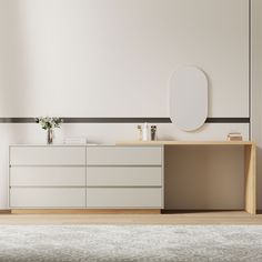 an empty room with a white dresser, mirror and vase on the floor in front of it