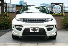 a white range rover parked in front of a building