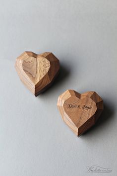 two wooden heart shaped magnets sitting on top of a table