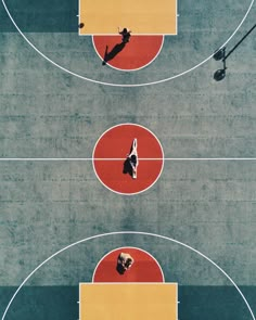 an overhead view of people playing basketball on a court with red and yellow lines in the middle