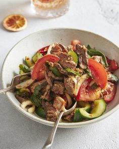 a white bowl filled with meat and vegetables