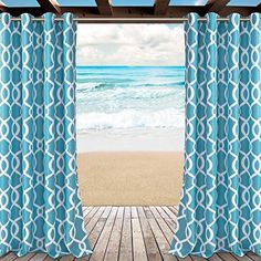 an open door to the beach with blue and white curtains hanging from it's side