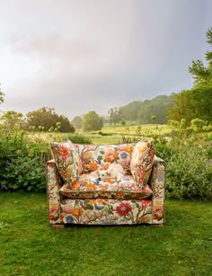 a couch sitting on top of a lush green field