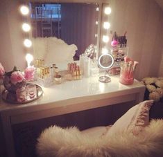 a vanity with lights and flowers on it