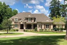 a large house with lots of trees in the front yard