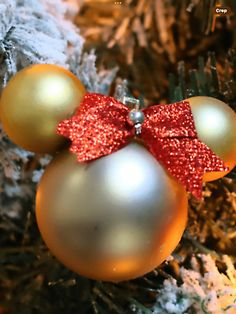 a mickey mouse ornament with a red bow on it's head is hanging from a christmas tree