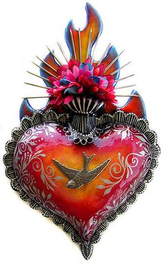 a red heart shaped sculpture with a bird on it's back and flowers in the middle