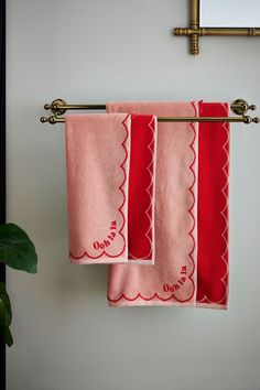 three towels hanging on a towel rack next to a potted plant