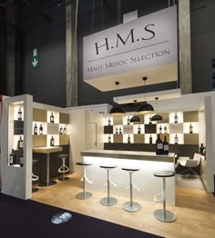 an exhibit booth with stools and bottles on display