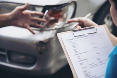 a person holding a clipboard in front of a car