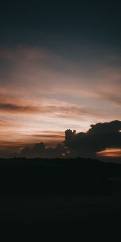 the sun is setting behind some clouds in the sky