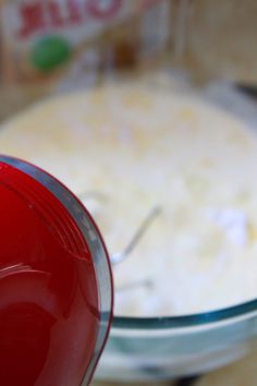 a red blender sitting in front of a bowl filled with rice and other ingredients