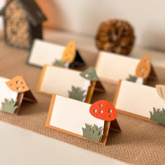 place cards with mushrooms on them are sitting on a table next to a bird house