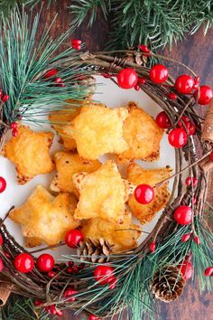 some food is sitting on a plate with pine cones and red berries around the edges