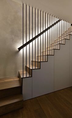 an image of a stair case with lights on the side and wood floors in front