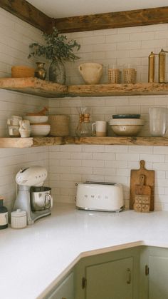 a kitchen with open shelving and white counter tops