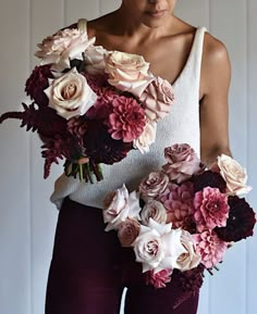 a woman holding a bouquet of flowers in her hands