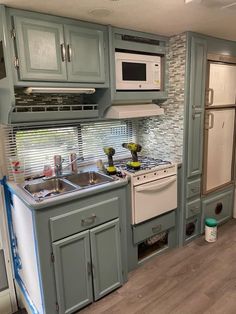 a kitchen with green cabinets and white appliances