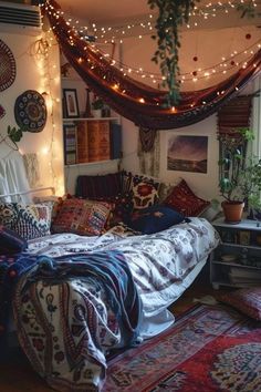 a bed with lots of pillows and blankets on top of it in a room filled with lights