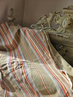 an unmade bed with a striped comforter on it