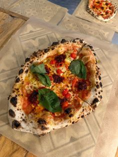 two small pizzas sitting on top of wax paper