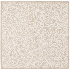 a rug with leaves on it in beige and white colors, the rug is made out of