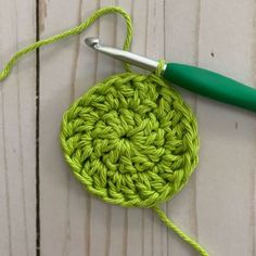 the crochet is being worked on with a green knitting needle