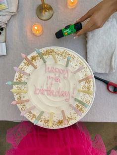 a birthday cake on a plate with candles and confetti in front of it