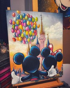 a painting of mickey and minnie mouse with balloons in front of a castle on an easel