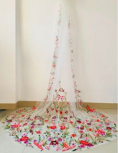 a white canopy with flowers on it in a room next to a wall and floor