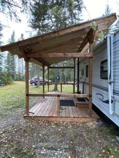 a small wooden porch next to a trailer