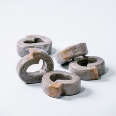 four cement rings sitting next to each other on top of a white surface with no one around them