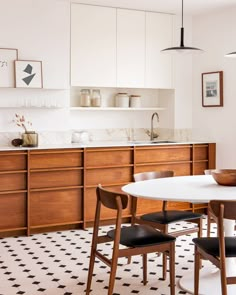 a kitchen with a table and chairs next to a counter top in front of cabinets