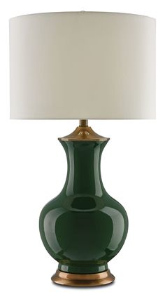 a green table lamp with a white shade on the top and gold trim around the base