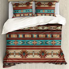 a bed covered in a colorful comforter next to a white pillow and two pillows